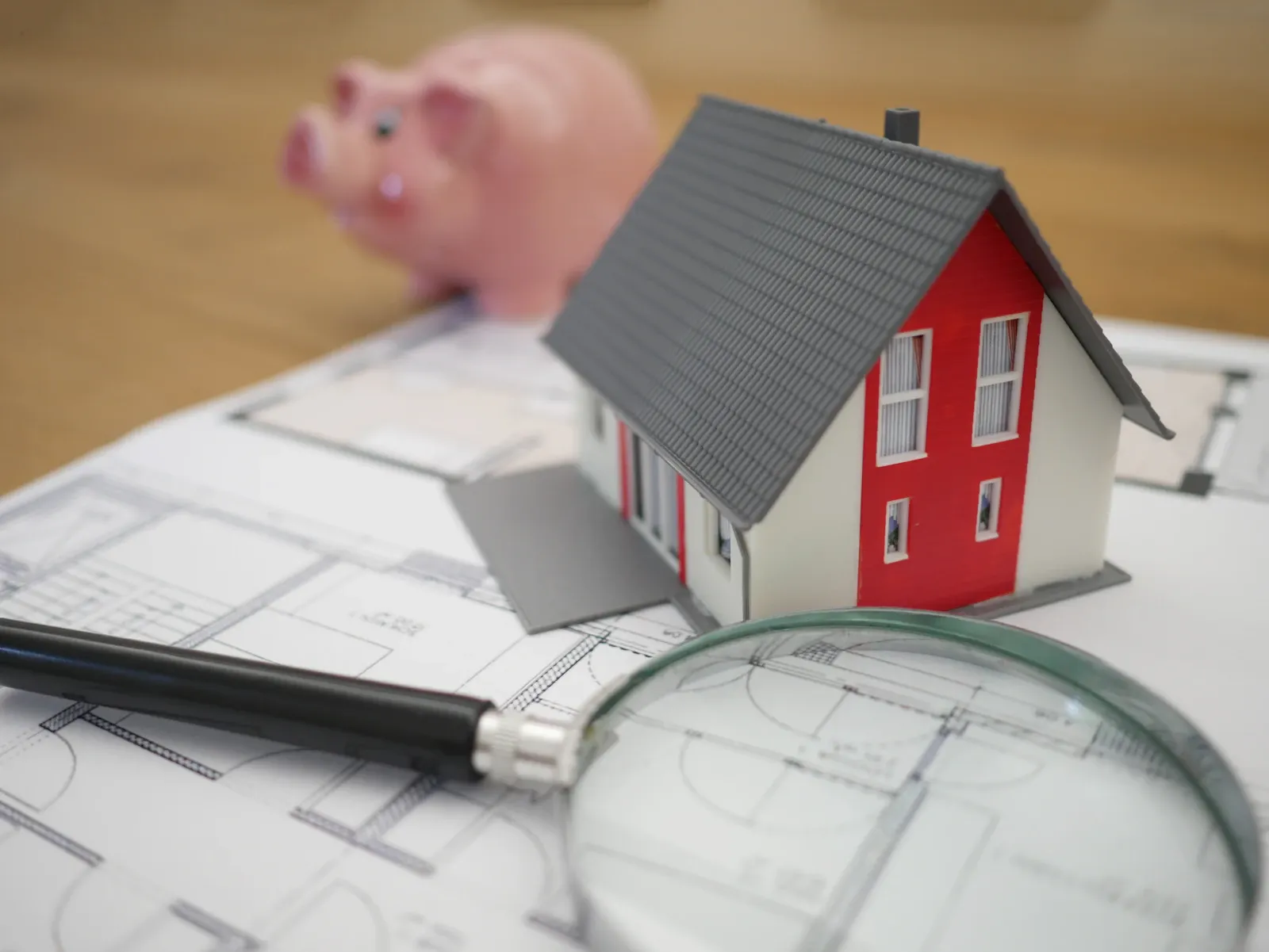 House model on top of loan paperwork for a Charter Funding personal loan